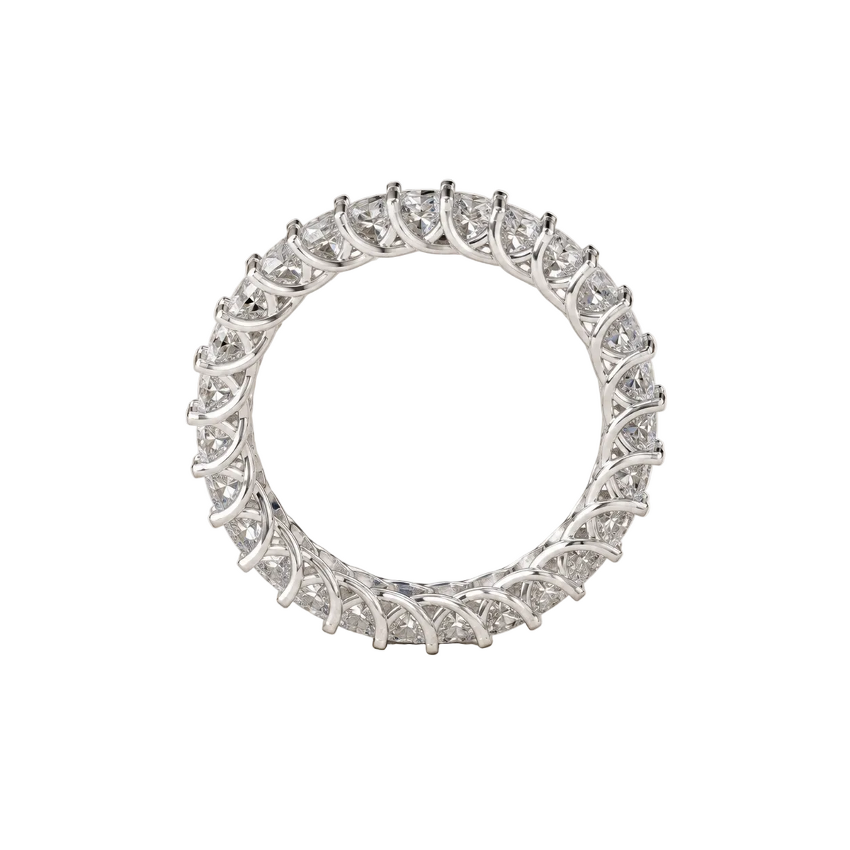 A silver-toned eternity ring set with small clear round-cut stones, photographed on a light textured neutral background.