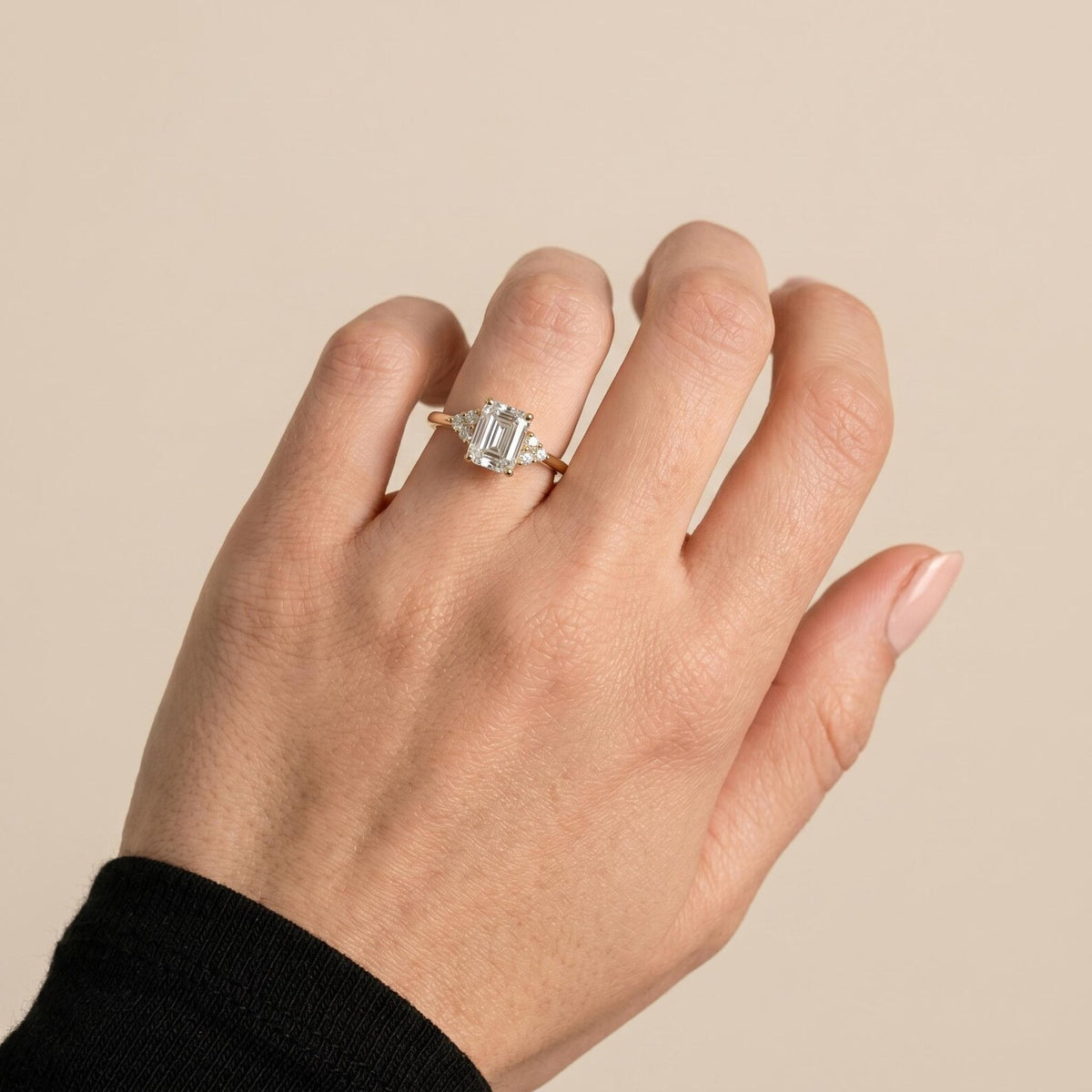 Engagement ring with a 2ct emerald cut solitaire with cluster accents and tapered band