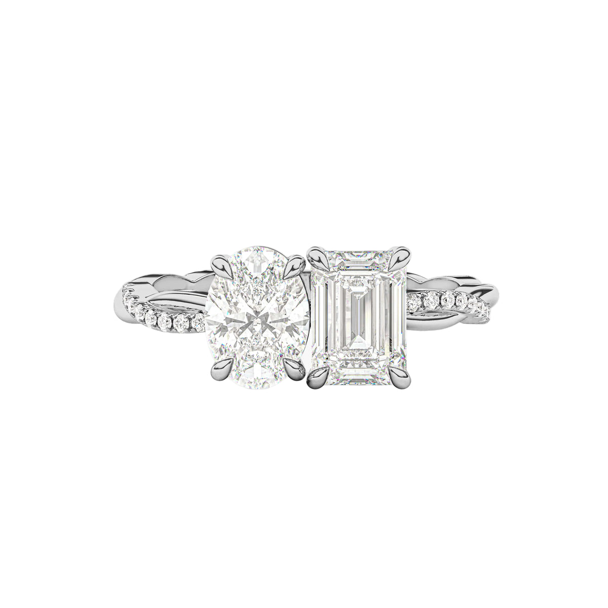 A silver-tone diamond engagement ring featuring a round brilliant-cut center stone and an emerald-cut side stone, set on a split pavé band, photographed on a clean white background with a soft shadow.