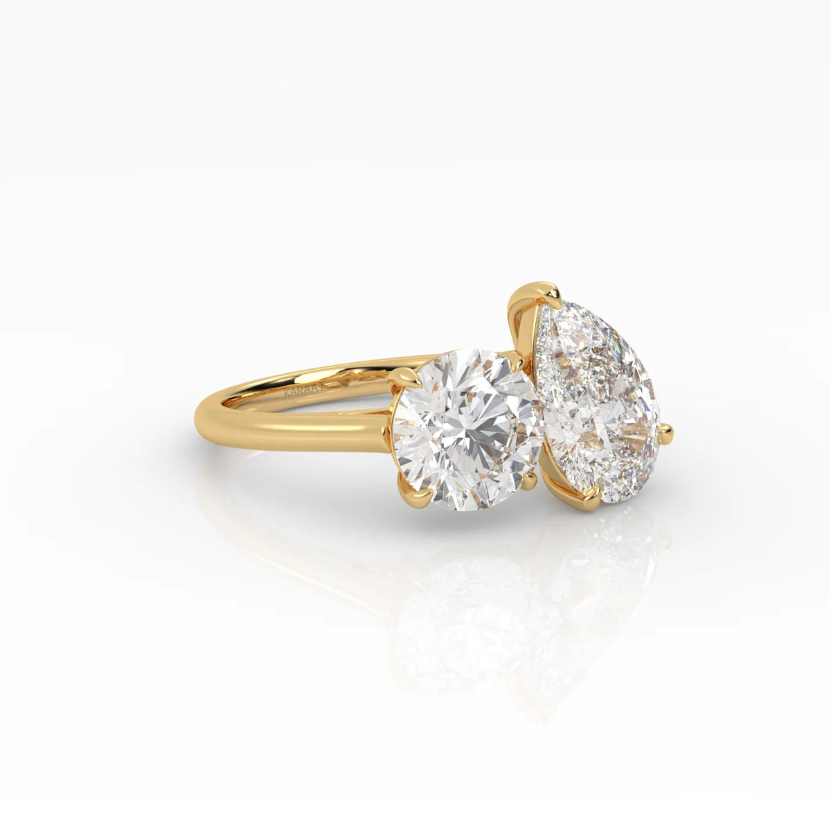 The Round and Pear Toi et Moi ring pairs the timeless brilliance